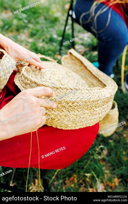 Hands of artisan making basket with esparto grass