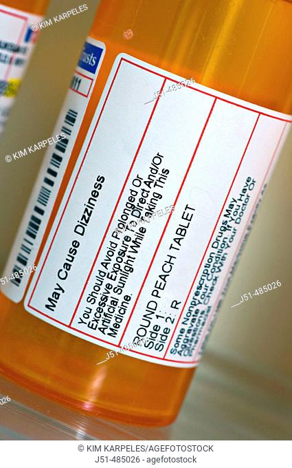 STILL LIFE. Riverwoods, Illinois. Close up of pharmacy label, warnings and precautions, bottle of prescription drug on shelf, bathroom medicine cabinet