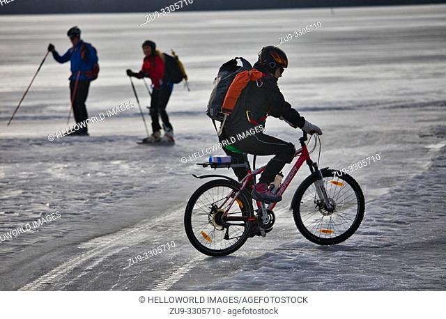 Cyclist and two long distance ice skaters on Lake Malaren during Sigtunarannet Vikingarannet 2019, Sigtuna, Sweden, Scandinavia
