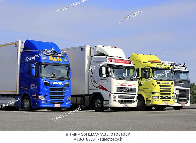 Hirvaskangas, Finland - August 24, 2018: Colorful Scania and Volvo freight transport trucks on asphalt yard of a truck stop on a day of summer
