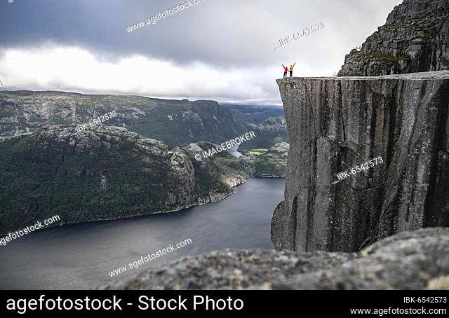 Two people at rock plateau, Preikestolen rock spire, Lysefjord, Ryfylke, Rogaland, Norway, Europe