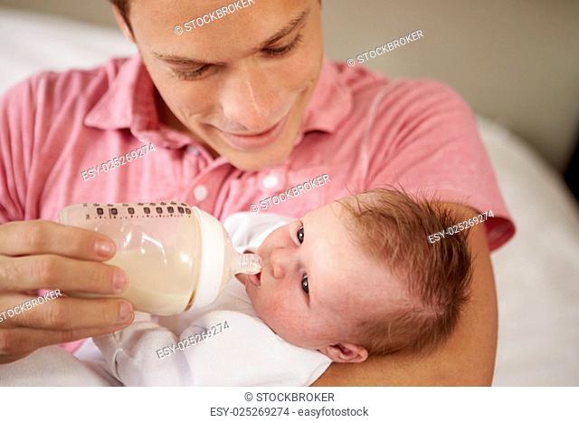 Father Giving Baby Daughter Bottle Of Milk