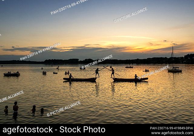 15 July 2023, Bavaria, Steinebach: Fisherman Thomas Aumiller (l) pushes his competitor Oliver Kaiser (r) into Lake Wörth during the finals for first place in...