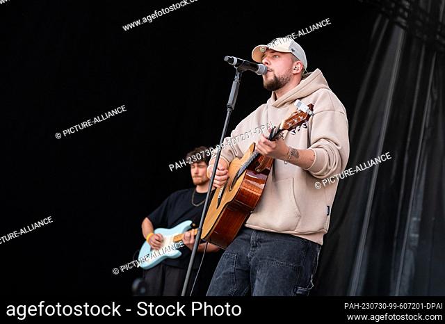 SYMBOL - 29 July 2023, Baden-Württemberg, Mannheim: Musician Luca Noel stands on stage with his guitar during a concert in the courtyard of honor of the Baroque...