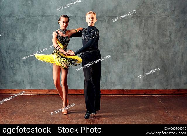 Young couple sport dancers dancing in ballroom dance cha-cha-cha