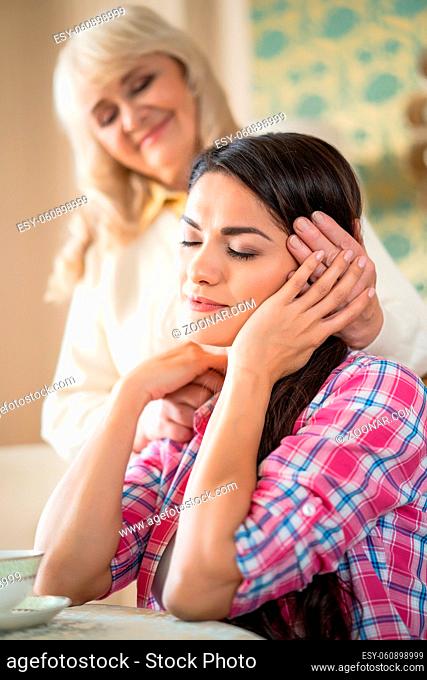 Pretty Brunette Girl Sits With Closed Eyes While Touching Her Mother's Hands Patting The Hair. Togetherness