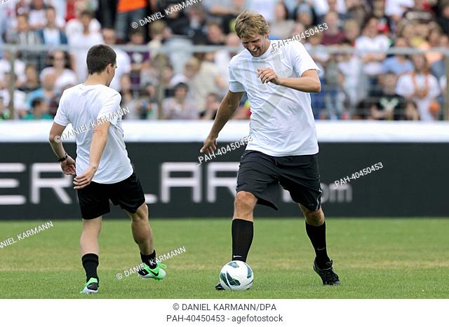 Basketball player Dirk Nowitzki (R) and biathlete Miachel Greis pass the ball before the charity soccer match between 'Manuel Neuer & Friends' and 'Nowitzki...