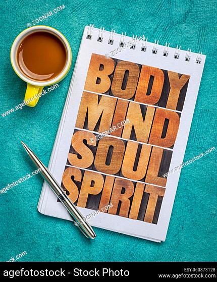 body, mind, soul and spirit - wellness concept - text created with letterpress wood type in an art sketchbook with cup of coffee