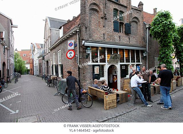 Street scene: people eating and talking in front of cafe Onder De Linden, one of the oldest cafes of the city of Amersfoort, Netherlands