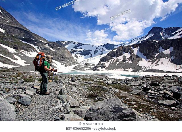 Young happy backpacker enjoying the mountain views in Wedgemount Lake Area of Garibaldi Park near Whistler, British Columbia, Canada