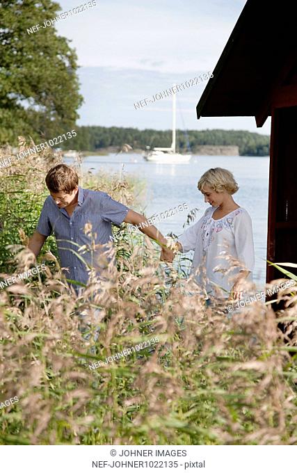 Sweden, Stockholm, couple holding hands at lake