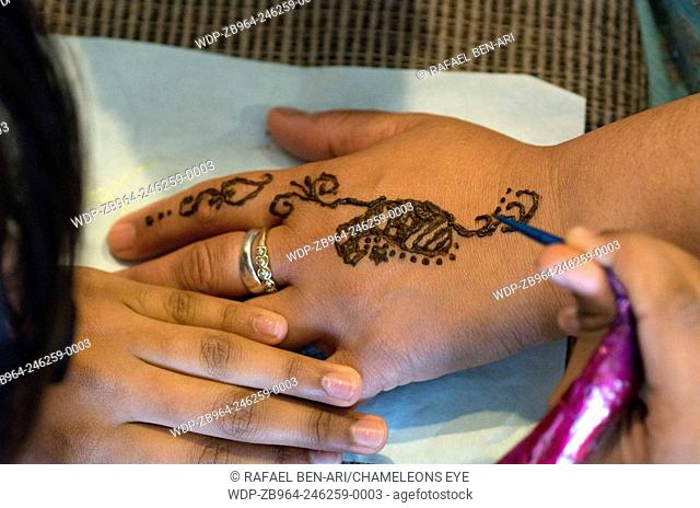 AUCKLAND, NZ - DEC 22:Indian women apply Henna/Mehndi body painting on Dec 22 2103.It's a ancient ceremonial art form which originated in India
