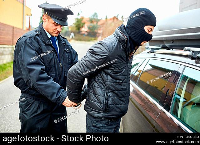 Streifenpolizist legt Handschellen an bei der Festnahme von einem Verbrecher