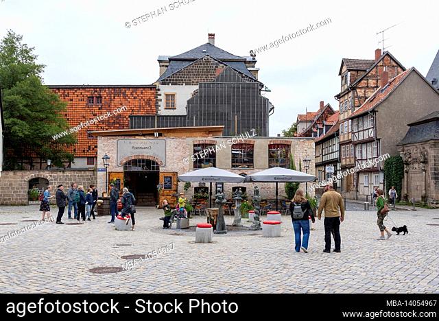germany, saxony-anhalt, quedlinburg, tourists stand at a fountain on the kornmarkt, behind it you can see the kornmarkt 3 restaurant