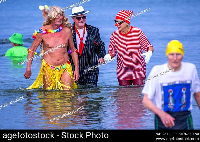 11 November 2023, Mecklenburg-Western Pomerania, Rostock: Members of the Rostocker Seehunde ice swimming club kick off the carnival season with colorful...
