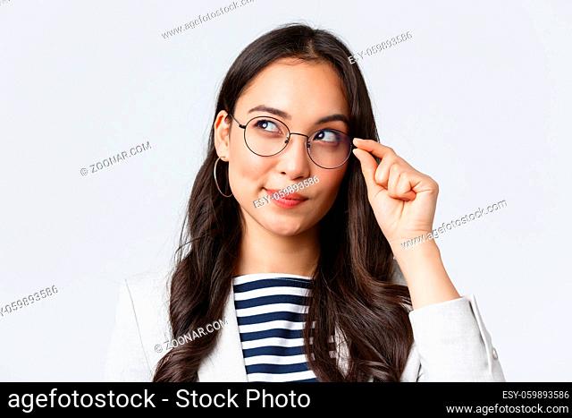 Business, finance and employment, female successful entrepreneurs concept. Close-up of intrigued asian woman looking upper left corner and smiling curious