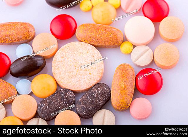 Tablets pills capsule heap mix therapy drugs, over a white background