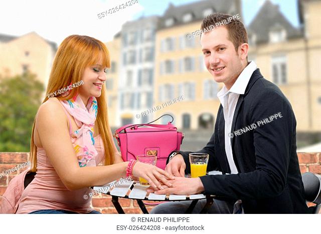 a cheerful young couple sitting in a coffee shop terrace