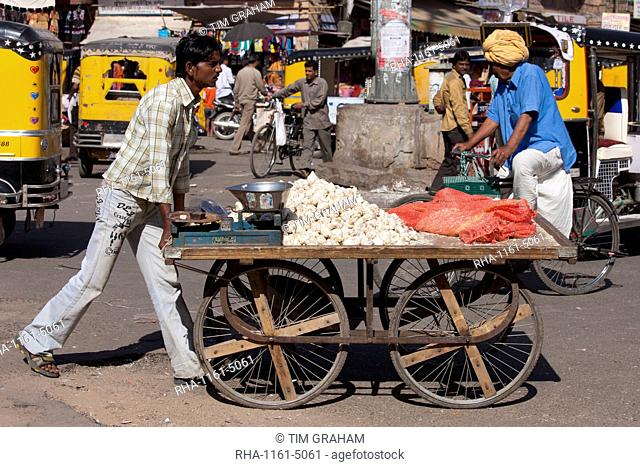 Garlic seller in street scene at Sardar Market at Girdikot, Jodhpur, Rajasthan, Northern India