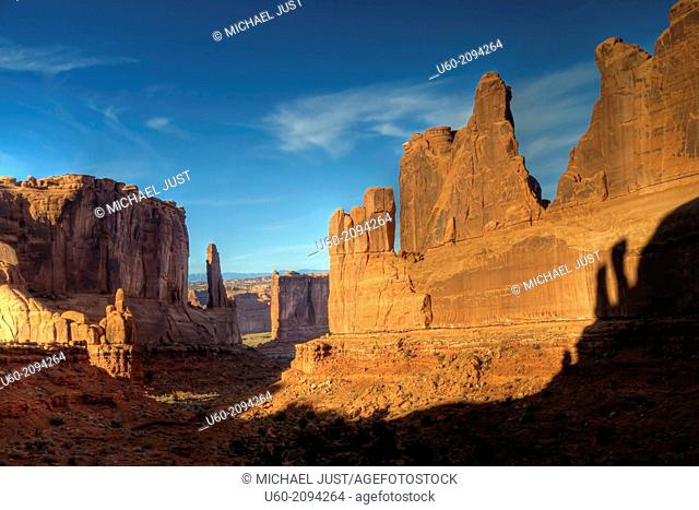 Shadows and silhouettes appear along the sandstone walls at Park Avenue at Arches National Park, Utah