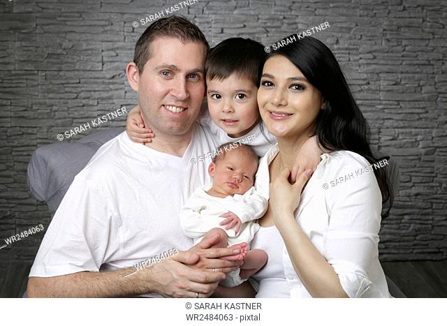 Happy parents with son and newborn baby