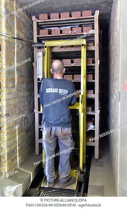 26 March 2019, Brandenburg, Glindow: An employee of the brick factory pushes a pallet of bricks into a drying chamber. The company with 20 employees produces...
