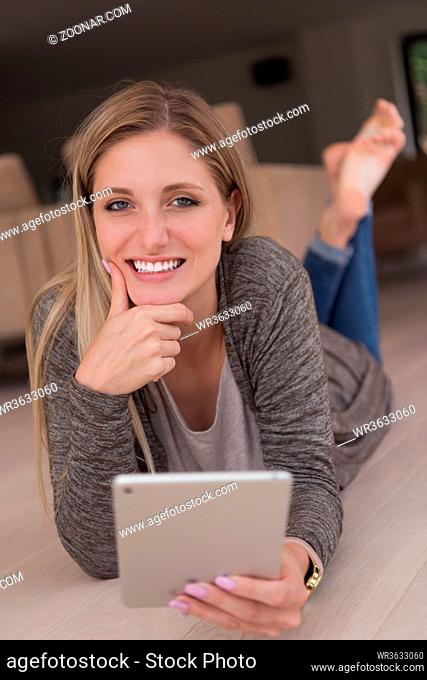 beautiful young women used tablet computer on the floor of her luxury home