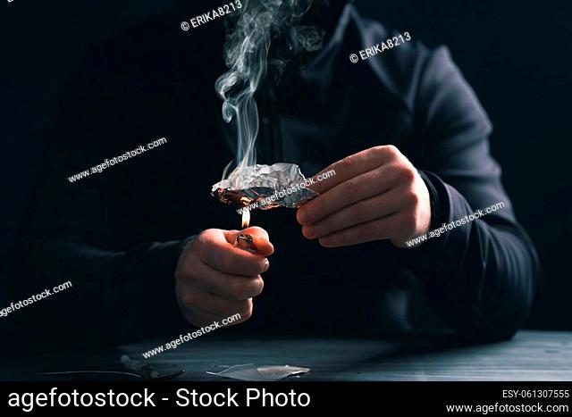 Addict/junkie man preparing drugs. The concept of crime and drug addiction
