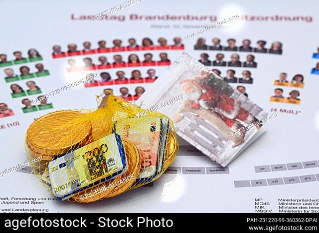 20 December 2023, Brandenburg, Potsdam: Chocolate coins lie on the tables of the MPs, who were given chocolate coins by Finance Minister Lange (SPD) before the...