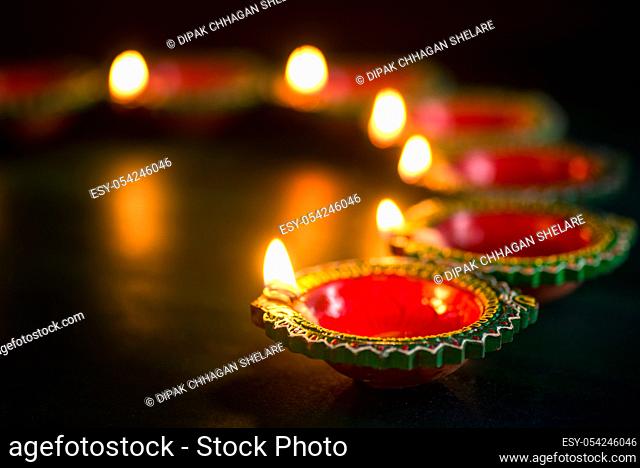 Happy Diwali - Clay Diya lamps lit during Diwali celebration. Greetings Card Design of Indian Hindu Light Festival called Diwali