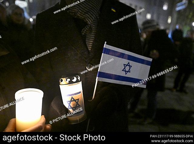 17 November 2023, North Rhine-Westphalia, Duesseldorf: Participants in the chain of lights in solidarity with Israel hold lights and Israel flags in a...