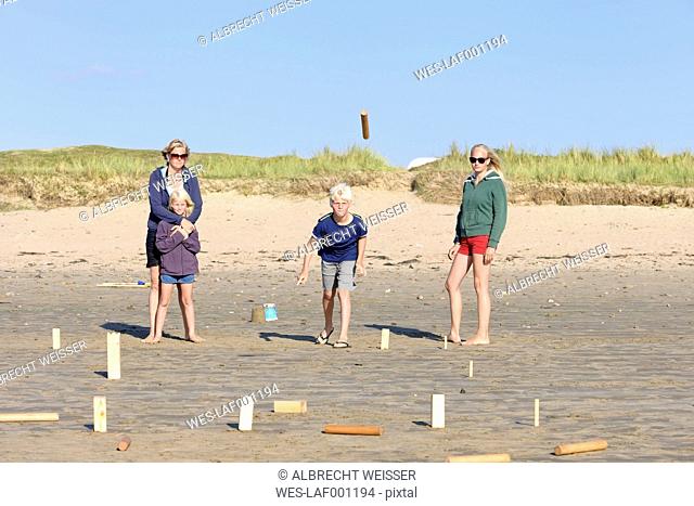 Mother and three children playing Kubb on the beach
