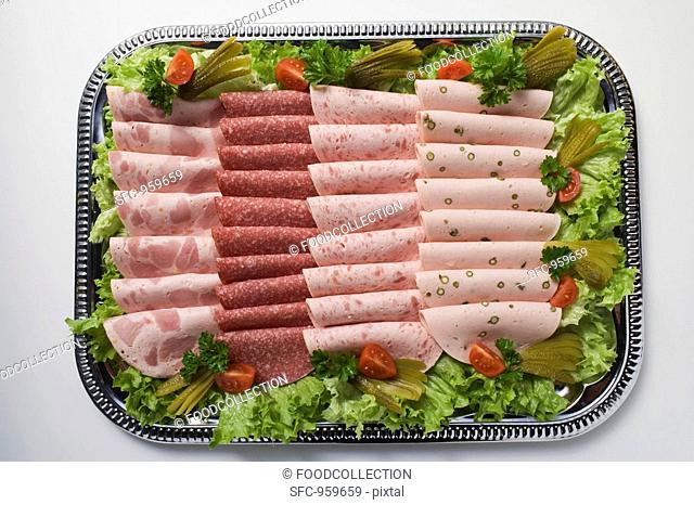 Cold cut platter garnished with gherkins overhead view