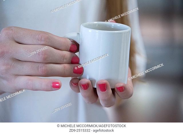 Closeup of a woman's hands holding coffee cup