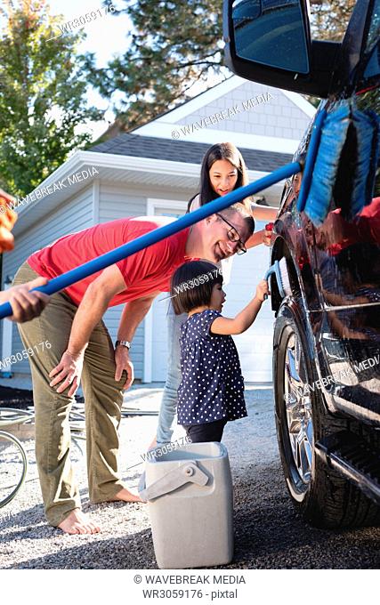 Father and kids having fun while washing car