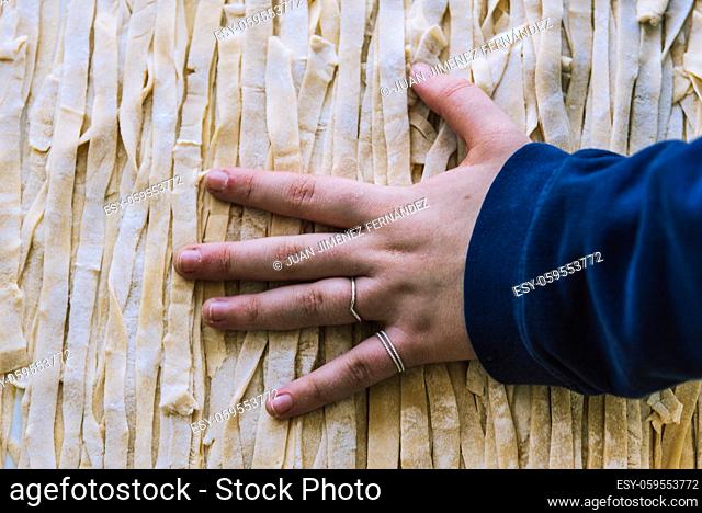Close-up of the process of making homemade pasta. Female chef prepares fresh traditional Italian pasta. Top view