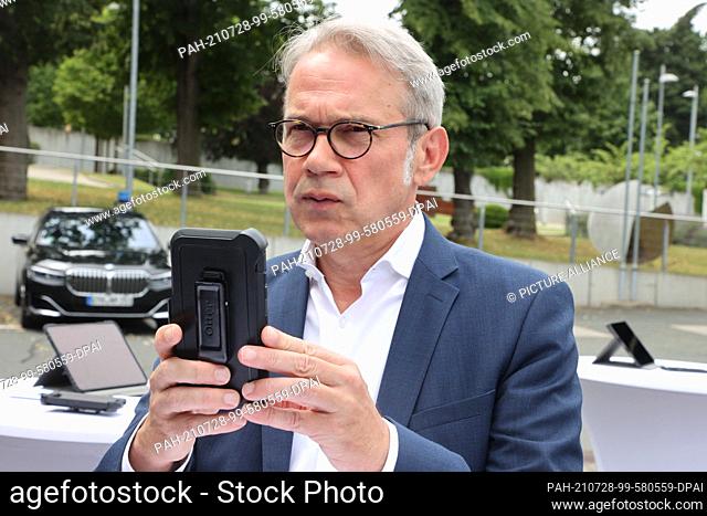 28 July 2021, Thuringia, Saalfeld: Georg Maier (SPD), Thuringia's Minister of the Interior, operates a mobile data device at the police station