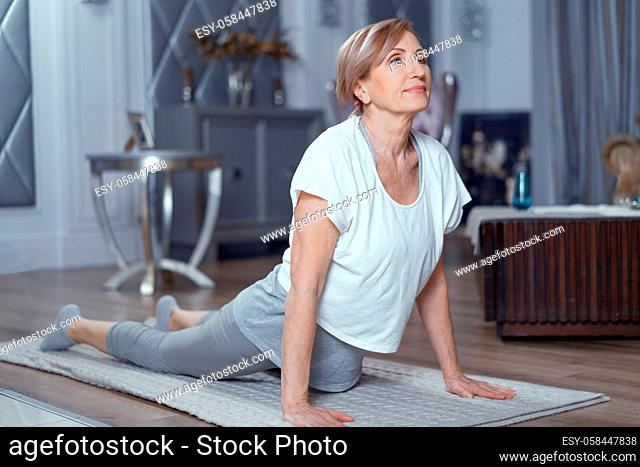 Sporty Mature Woman Bends To Do Upward-Facing Dog Pose. Practicing Yoga Upward-Facing Dog Pose. Healthy Lifestyle
