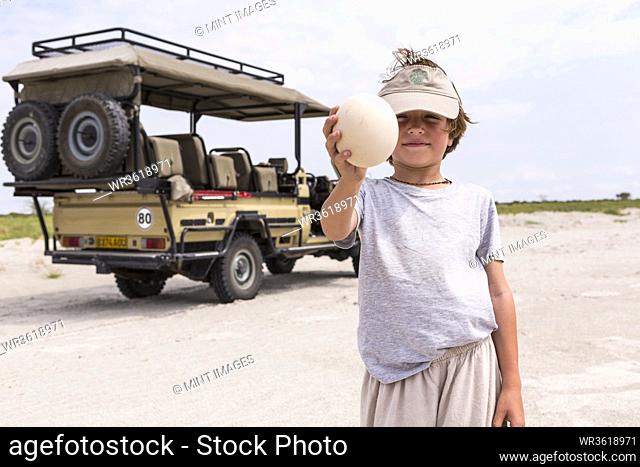 Boy holding up a large ostrich egg