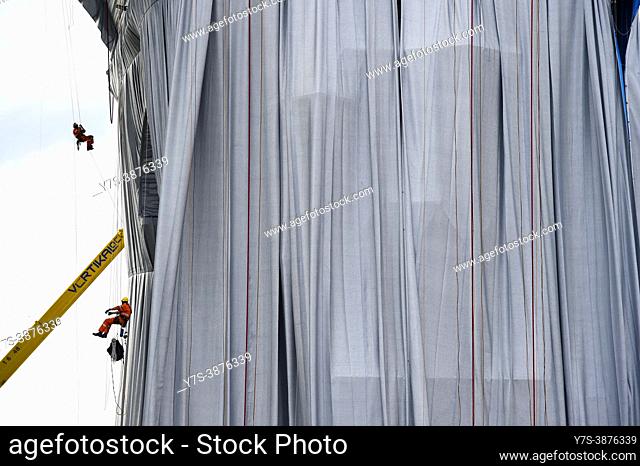 Workers install a shimmering wrapper to envelop Paris landmark, the Arc de Triomphe, in a posthumous installation by artist Christo on the Champs Elysee avenue...