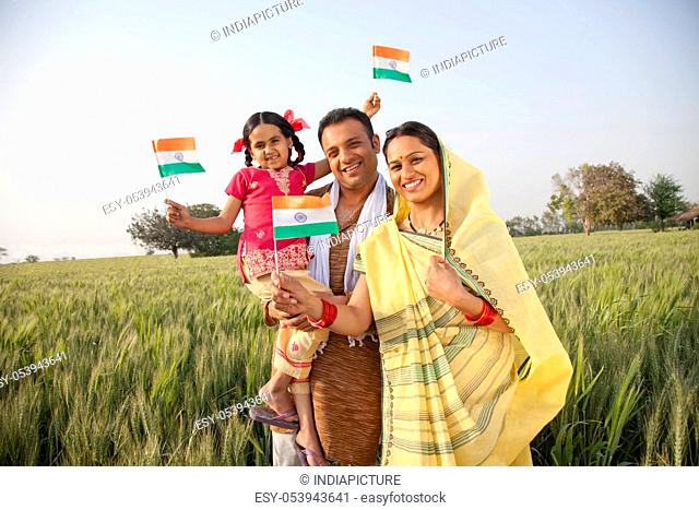 Portrait of a rural family holding an Indian flag