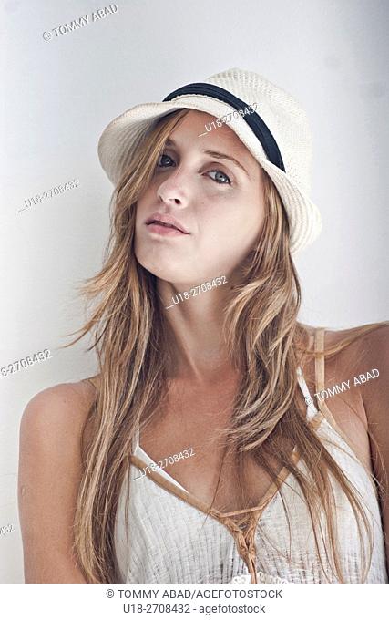 blonde woman with a panama hat and white dress / white background