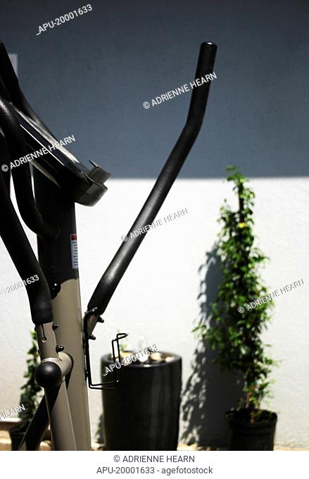 Elliptical bike against a grey wall