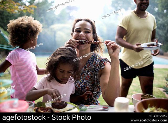 Mother and daughter enjoying barbecue lunch on patio