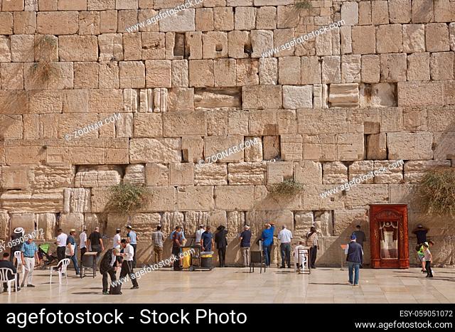 Jerusalem, Israel - October 23, 2017: People praying at the Western 'Wailing' Wall of Ancient Temple in Jerusalem. The Wall is the most sacred place for all...