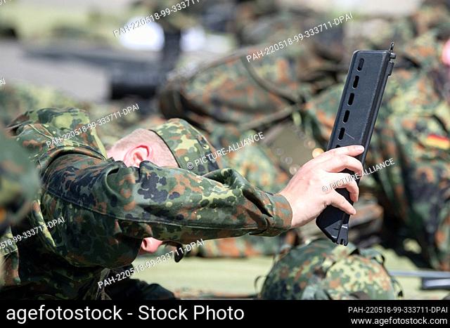 11 May 2022, Bavaria, Hammelburg: A recruit being trained for the reserve holds a component of the G36 assault rifle at the German Army's Hammelburg training...