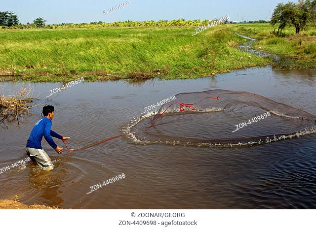 Fischer beim Auswerfen eines Wurfnetzes in einem Fluss, Battambang, Kambodscha / Fisherman throwing a cast net in a river, Battambang, Cambodia