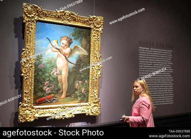 RUSSIA, MOSCOW - JUNE 5, 2023: A woman stands before Cupid Shooting a Bow by Carle van Loo, 1761, during an exhibition titled ""Salons by Diderot