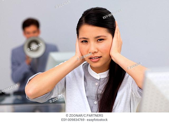 Businesswoman covering her ears