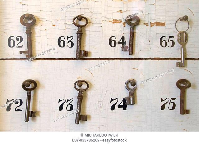 Vintage keys with numbers hanging in an old closet